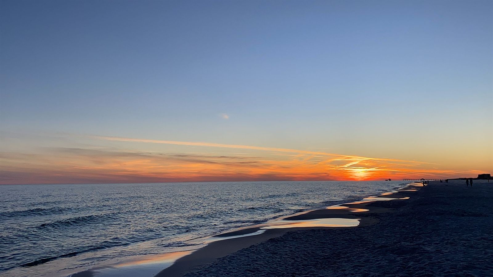 Sunset over the Gulf on the wet sand of a Gulf Shores beach, among the best-known Alabama beaches